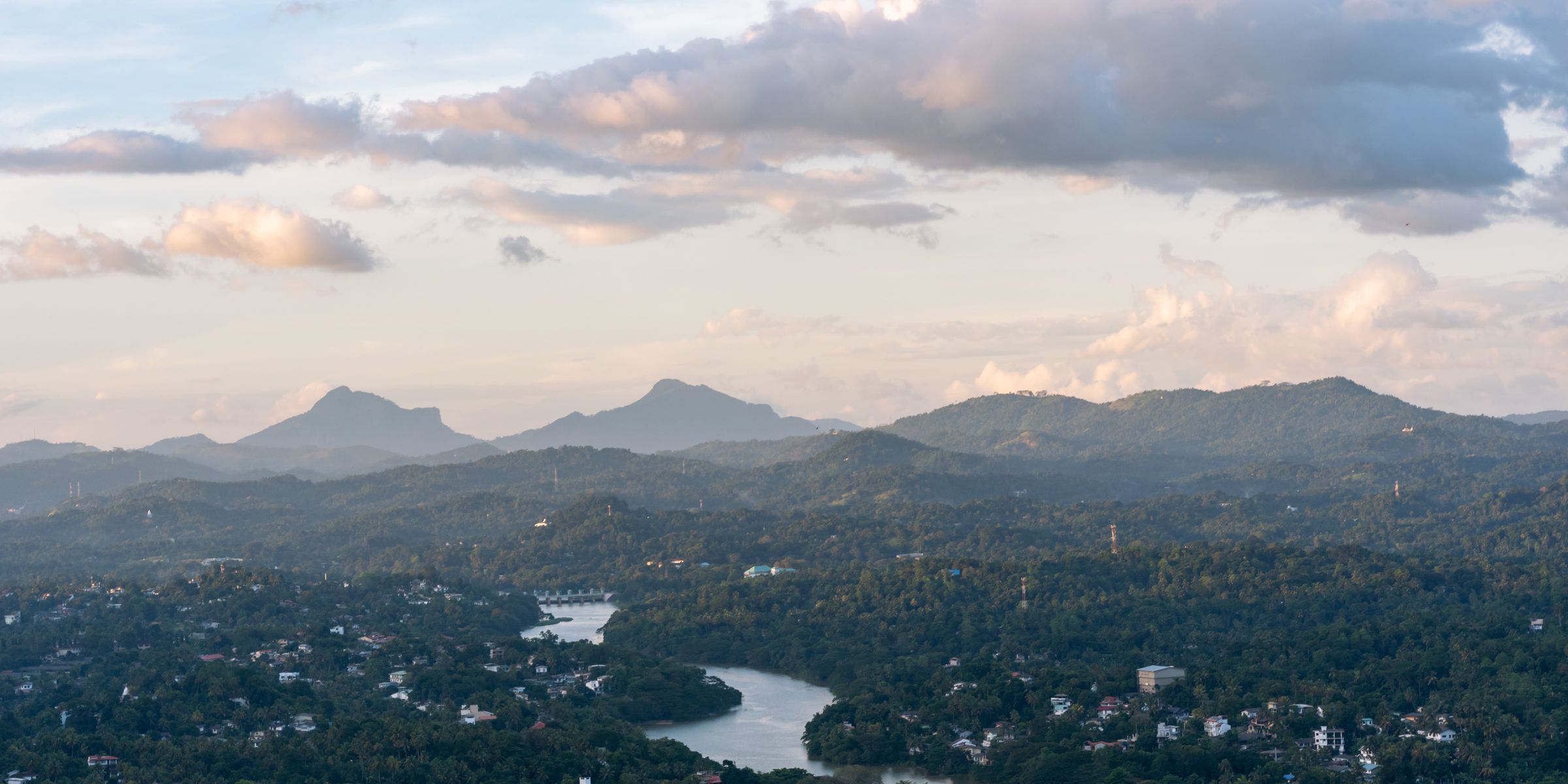 Green hills and a calm river winding through the interior of Sri Lanka