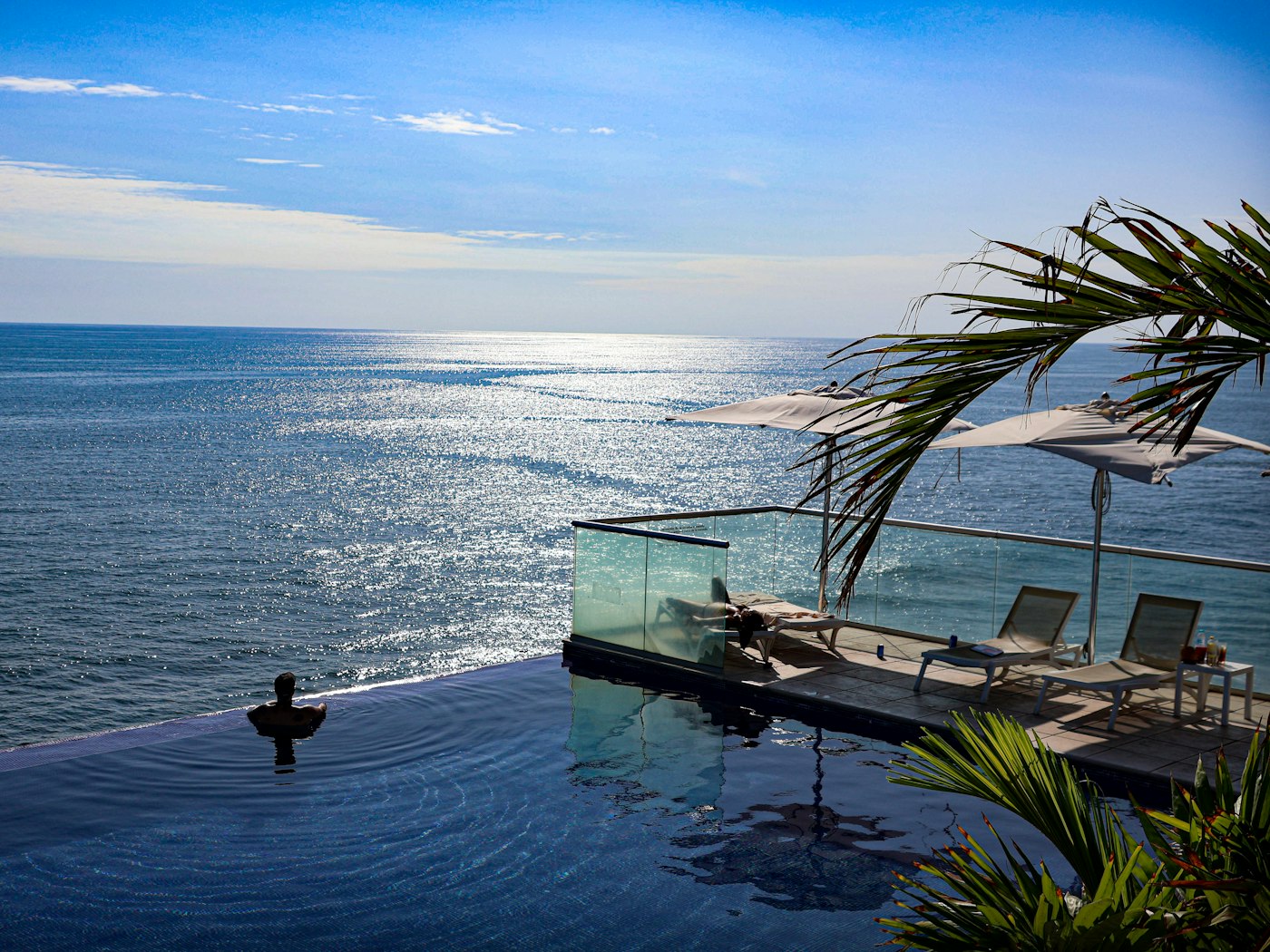 An infinity pool at a boutique retreat looking out over the Indian Ocean at sunset